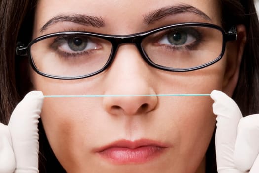 Close_up of a female dentist holding dental floss