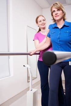 Physiotherapist assisting a patient in walking