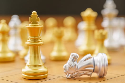 Gold king chess piece and siver horse on wood chessboard ,Concept of leadership game of strategy