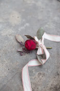 Red rose with ribbon on the concrete ground. High quality photo