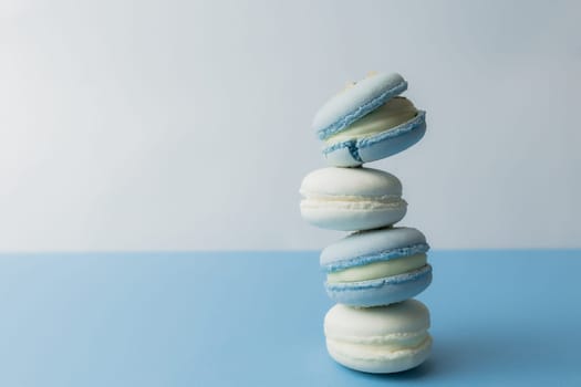 White and blue macaroons on the table, macaroons on blue background. High quality photo