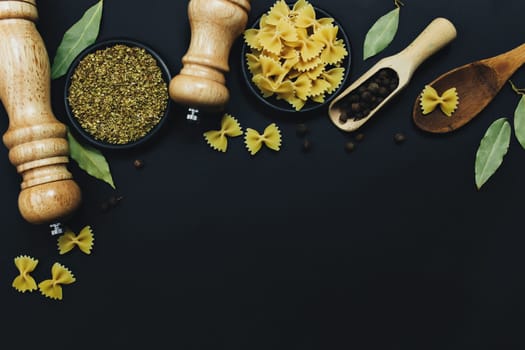 Seasonings, herbs and pasta on black background. High quality photo