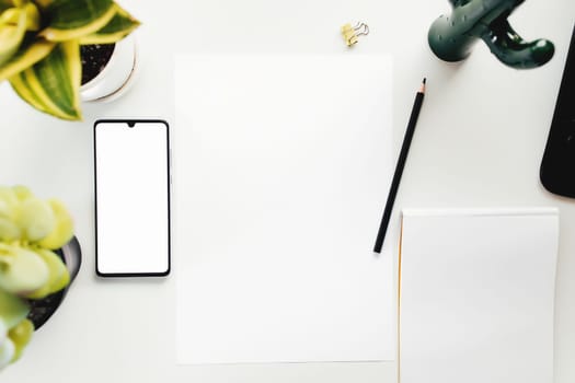 Smartphone on white table, work from home, office stuff. High quality photo