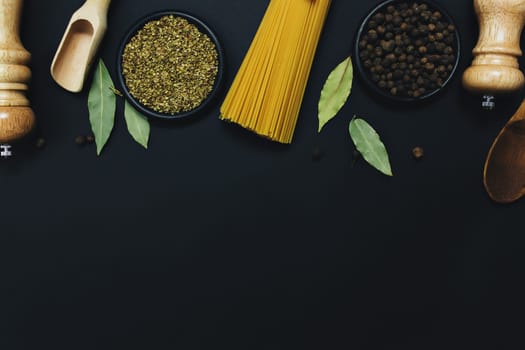 Seasonings, herbs and pasta on black background. High quality photo