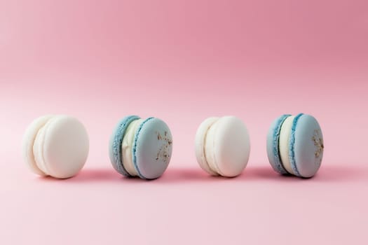 White and blue macaroons on the table, macaroons on pink background. High quality photo