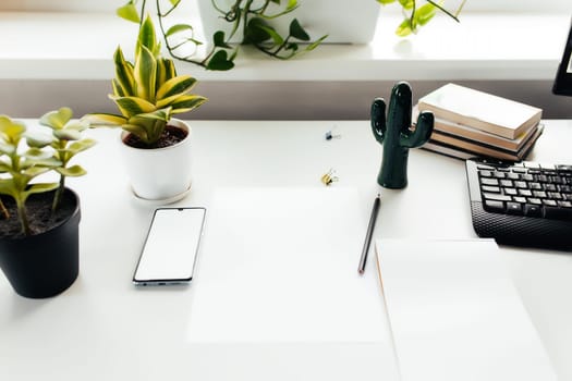 Smartphone on white table, work from home, office stuff. High quality photo