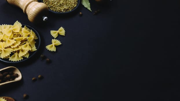 Seasonings, herbs and pasta on black background. High quality photo
