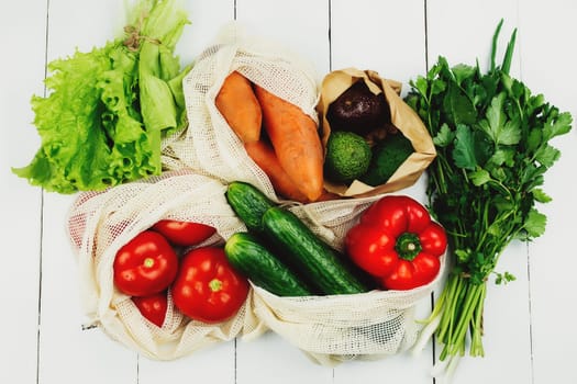 Fresh vegetables in eco bags on white table. High quality photo