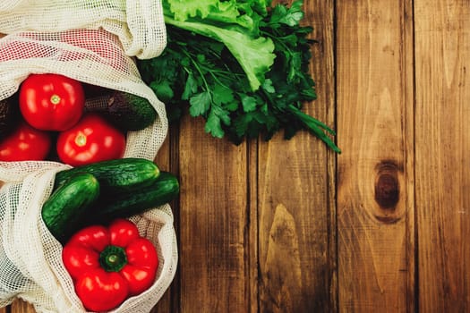 Fresh vegetables in eco bags on wooden table. High quality photo