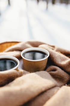 Two cups of coffee on a scarf in the snowy forest. High quality photo