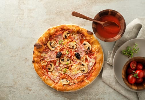 Pizza served with cheese, ham, mushrooms, olives  and tomato sauce