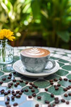 Cup of cappuccino with drawing on light gray background side view
