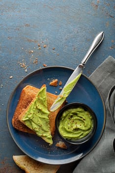A dish of mashed avocado mixed with chopped onion, tomatoes, chili peppers, and seasoning