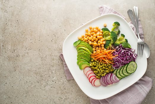 Healthy vegan lunch plate. Vegetarian salad with Avocado, chickpeas, red cabbage, green peas, red onion and broccoli