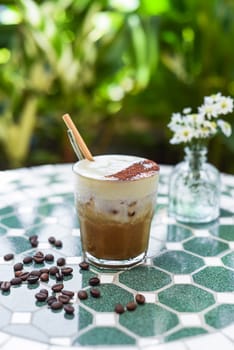 Vietnamese salted coffee with salty cheese cream (ca phe muoi) against green leaves
