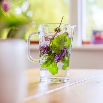 Cold jar of fresh water with delicious colorful herbs
