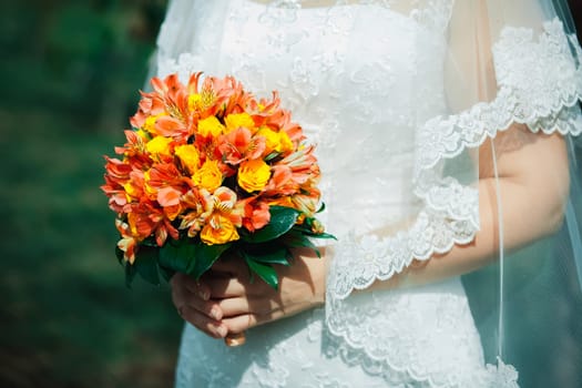 Bride with a bouquet of orange flowers. Wedding bouquet.