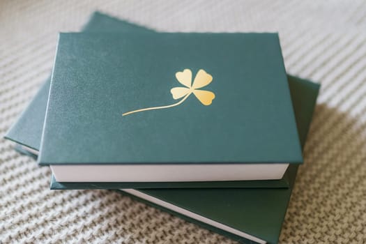 Green knika with clover on the cover. Two books.