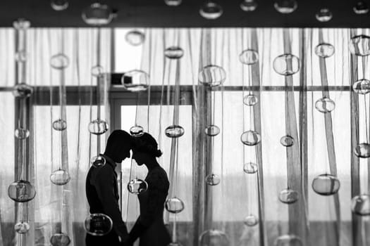 The bride and groom at the window, silhouettes of the newlyweds.