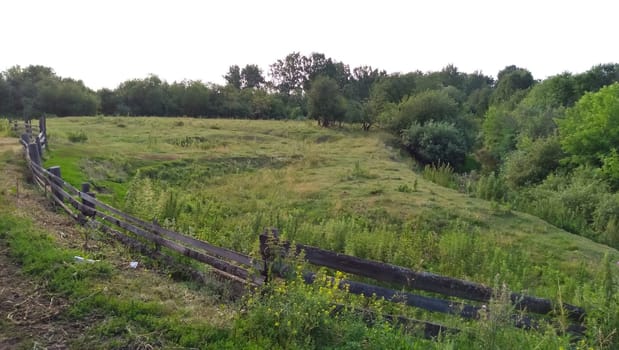 A wooden fence on a pastibish near the river.