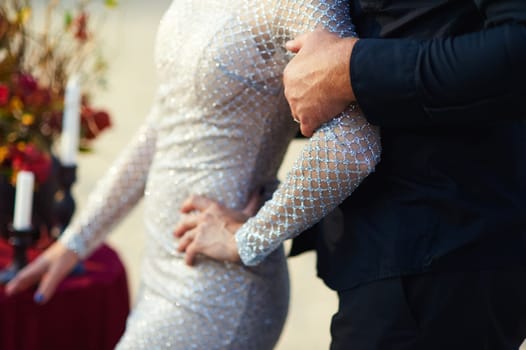 The groom holds the weight by the arm. Wedding photo.