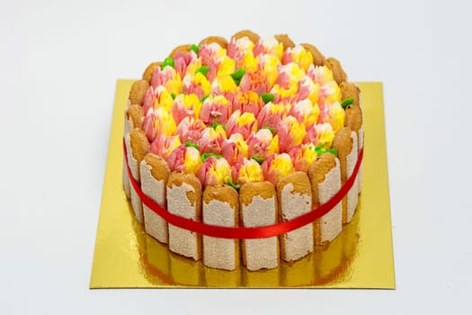 Cream cake with cookies and patterns in the form of a bouquet of tulips.