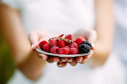 Wedding koets on a plate with raspberry berries.