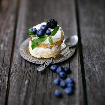 A small cake with blueberries and blackberries.