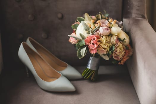 White bride shoes and a bouquet of flowers.