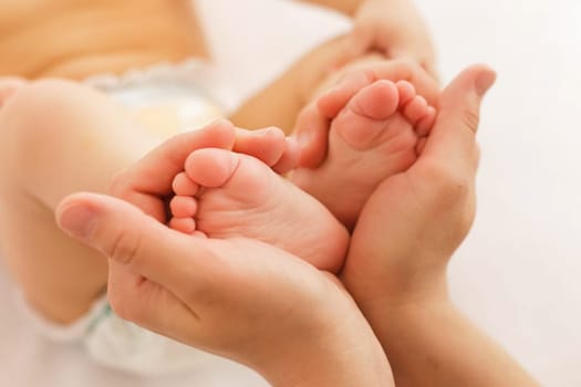 The mother holds the baby's legs.