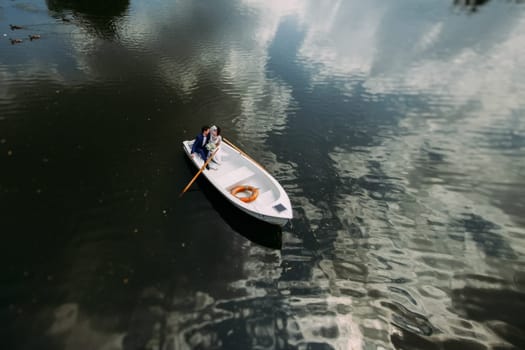 Newlyweds on a white boat swim in the lake.