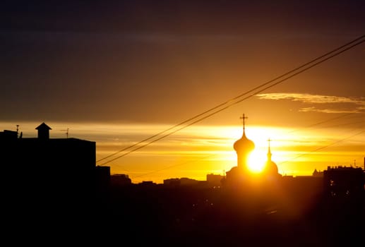 Sunny sunset against the dome of the church. Sunset over the city.