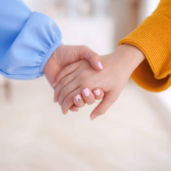 The mother's hand holds her daughter's hand. mother and daughter.