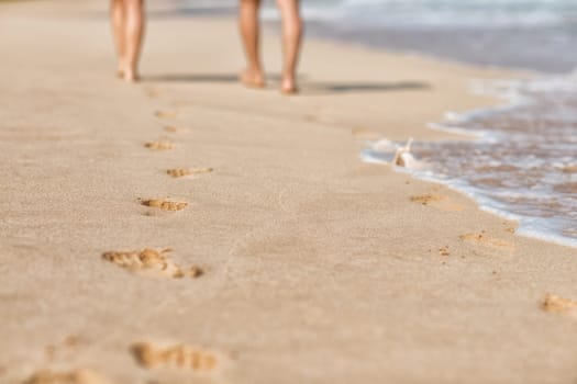 Traces on the sandy shore of the sea from people walking.