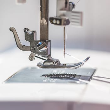 Close up of sewing metal sewing needle with sewing thread