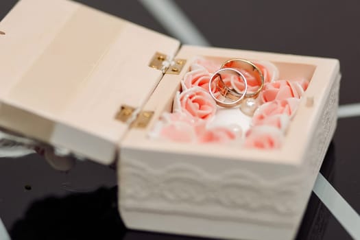 Wedding rings in a white casket. With flowers