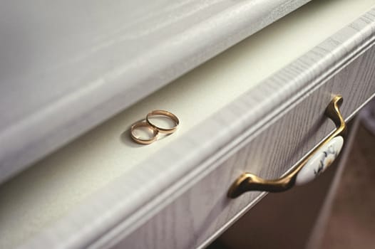 Two wedding rings on a white table. Wedding