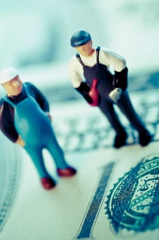 Figurines of two construction workers on the US paper currency
