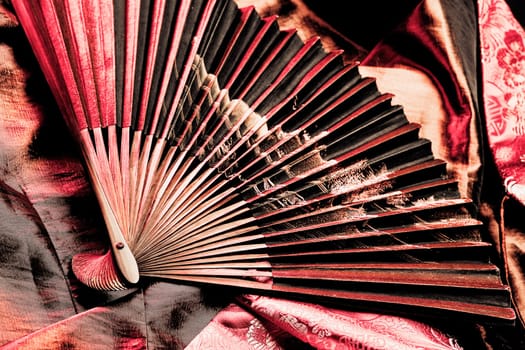 Details of a folding fan on fabric