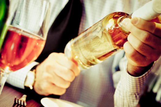 Mid section view of a man holding a wine bottle