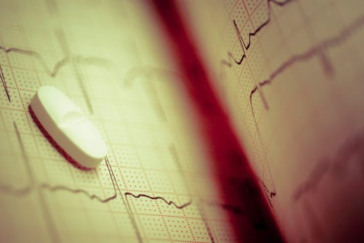 Close_up of a pill on an ecg report