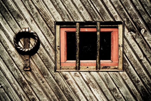 Close_up of a window with knocker on a wooden door