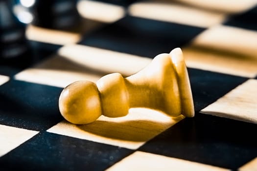 Close_up of a fallen pawn on a chessboard