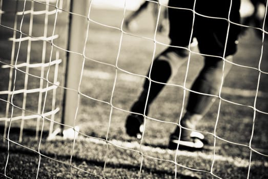 Low section view of a goalie at the goal post