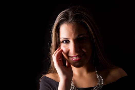 Young beautiful woman standing against black background