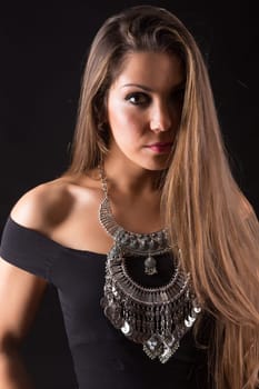Young beautiful woman standing against black background