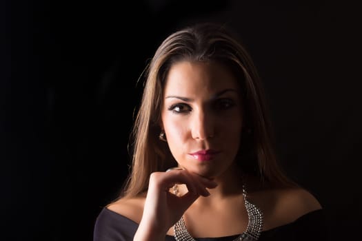 Young beautiful woman standing against black background