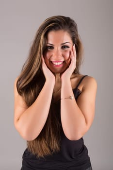 Young beautiful woman standing against gray