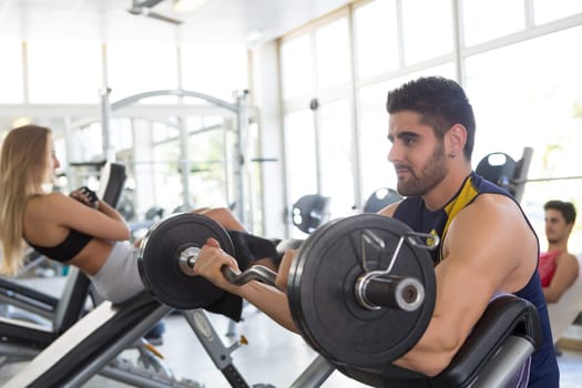 Handsome young man working out at the gym