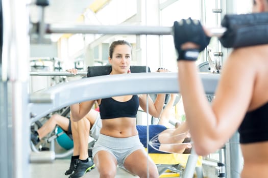 A young and beautiful woman working out at the gym